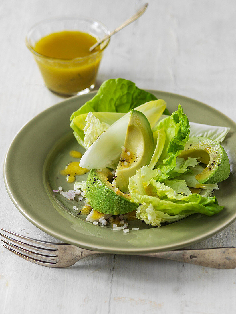 Avocado winter salad with endive, lettuce, chopped shallots and mustard dressing