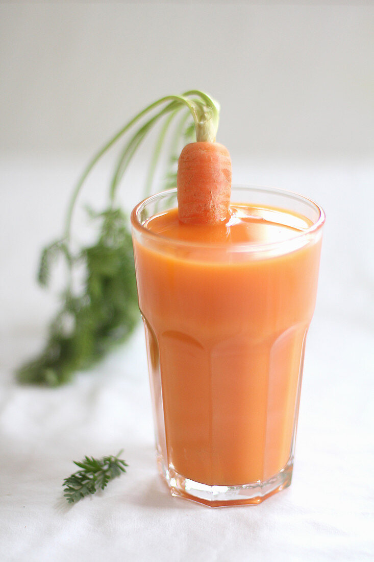 A carrots in a glass of carrot juice