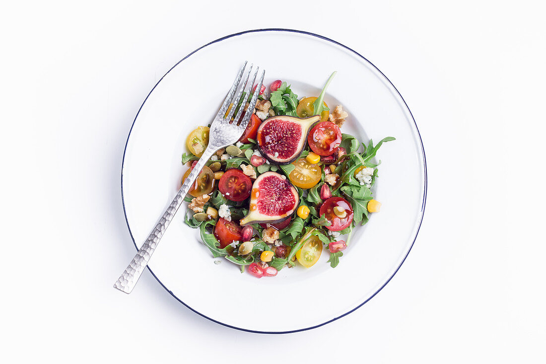 Tasty vegetable salad with fig served with fork