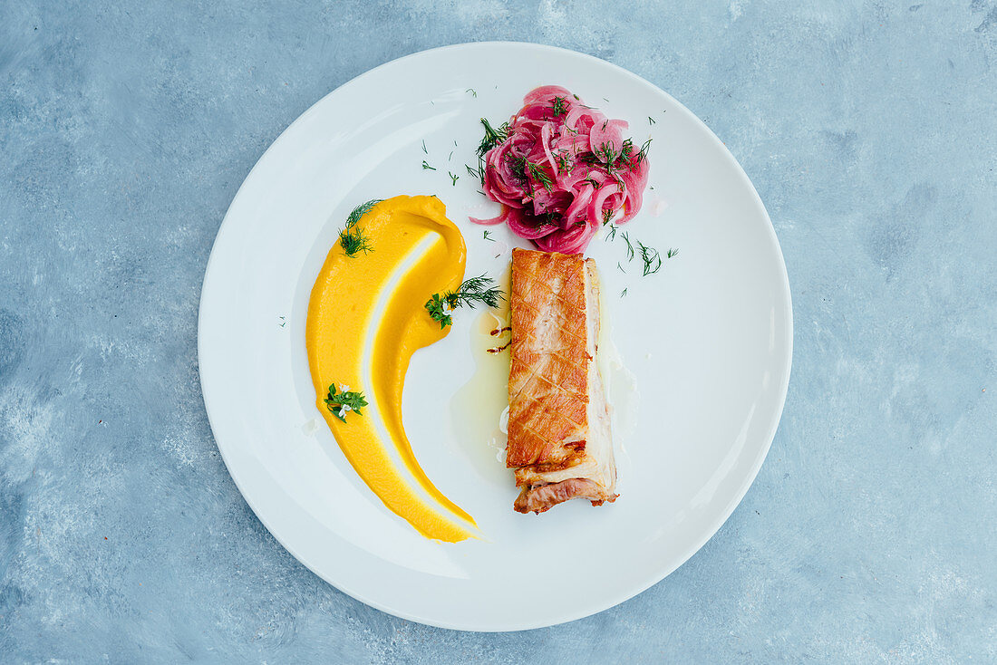 Mangaliza-Schweinefleisch mit Karottenpüree und rotem Zwiebelsalat