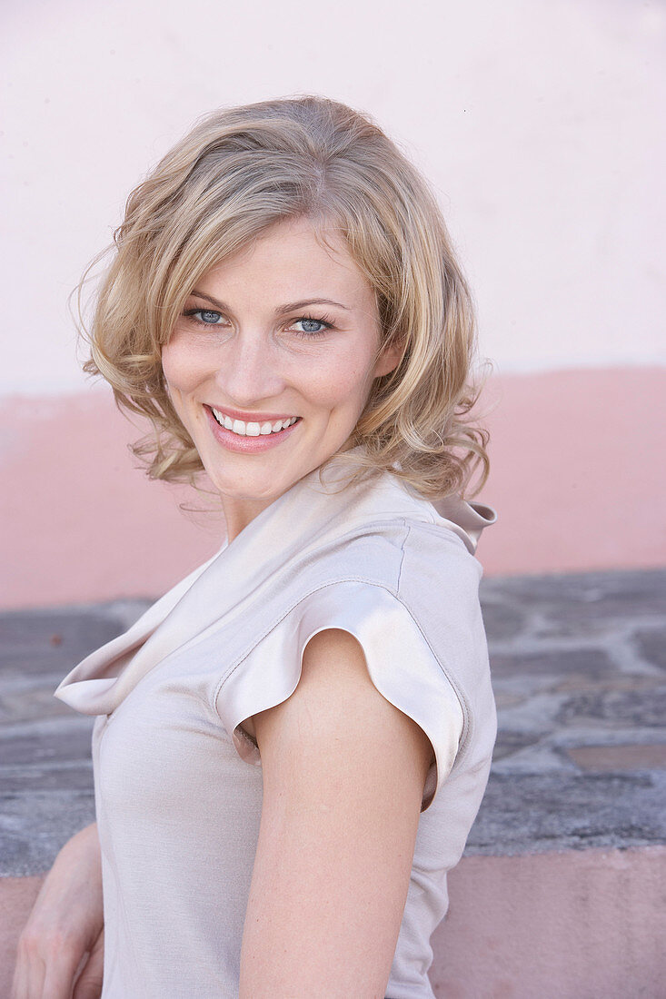 A blonde woman wearing a light blouse