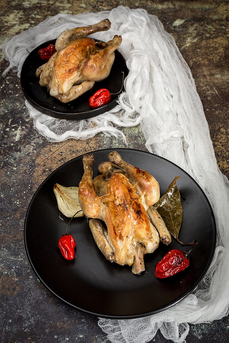 Roast chicken with onions, garlic, peppers and aromatic herbs