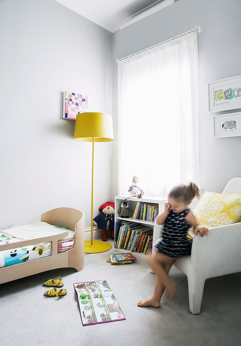 Girls in light gray children's room with yellow accents