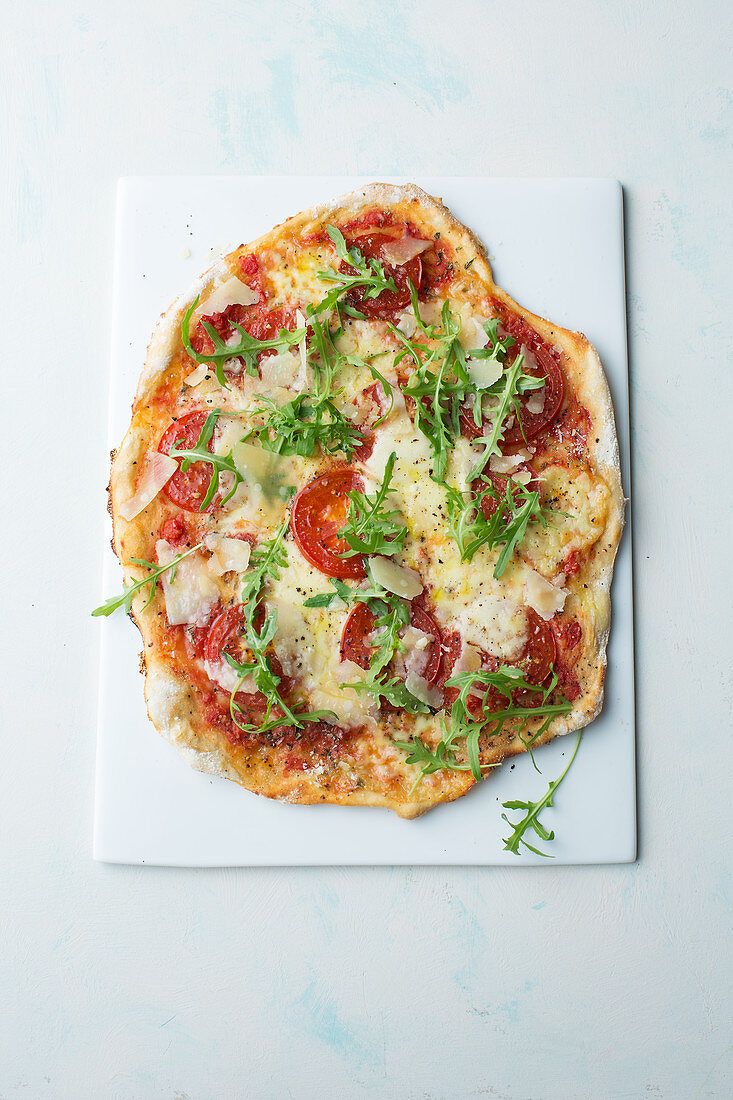 Pizza with tomatoes, cheese and rocket