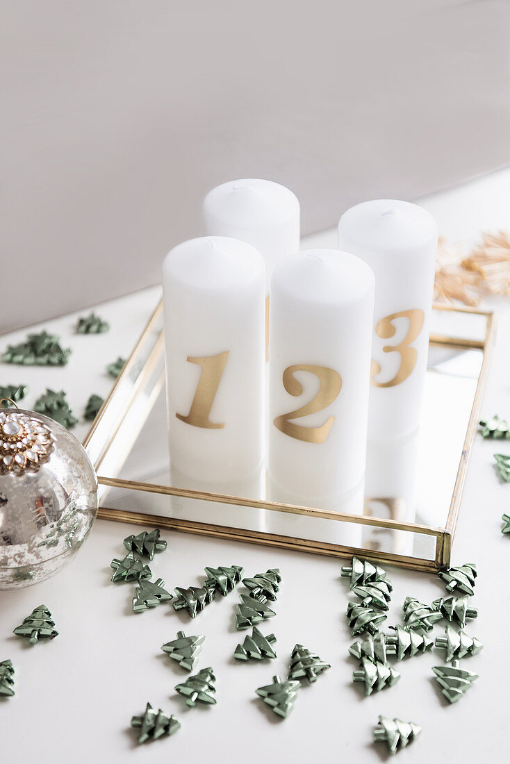 DIY-Adventsschmuck mit Kerzen und Streudeko auf Spiegelplatte