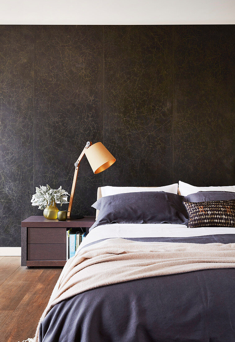 Black marble wall behind the bed in the bedroom