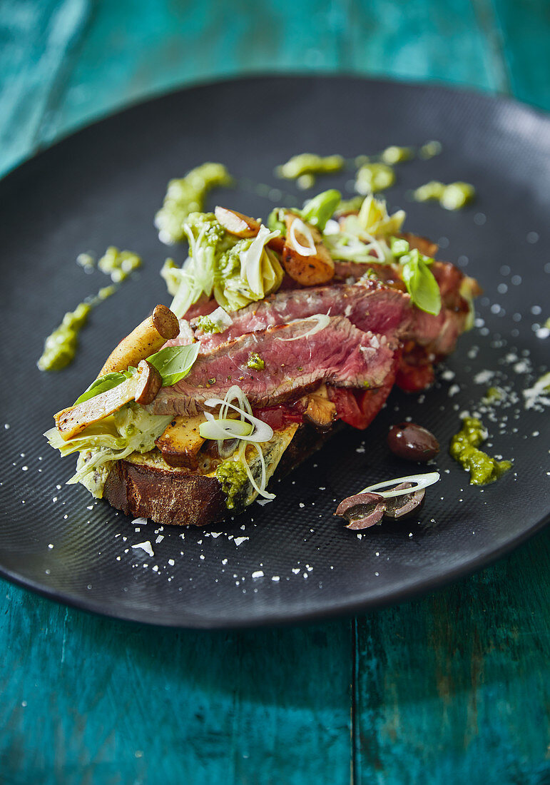 Steak-Sandwich mit Tomaten, Artischocken und Pilzen