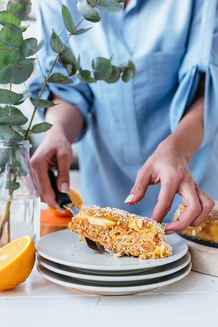 Person putting a slice of pumpkin and oranges tart on the plate