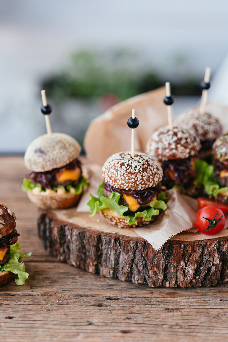 Small meat burgers with fresh salad on a wooden plate