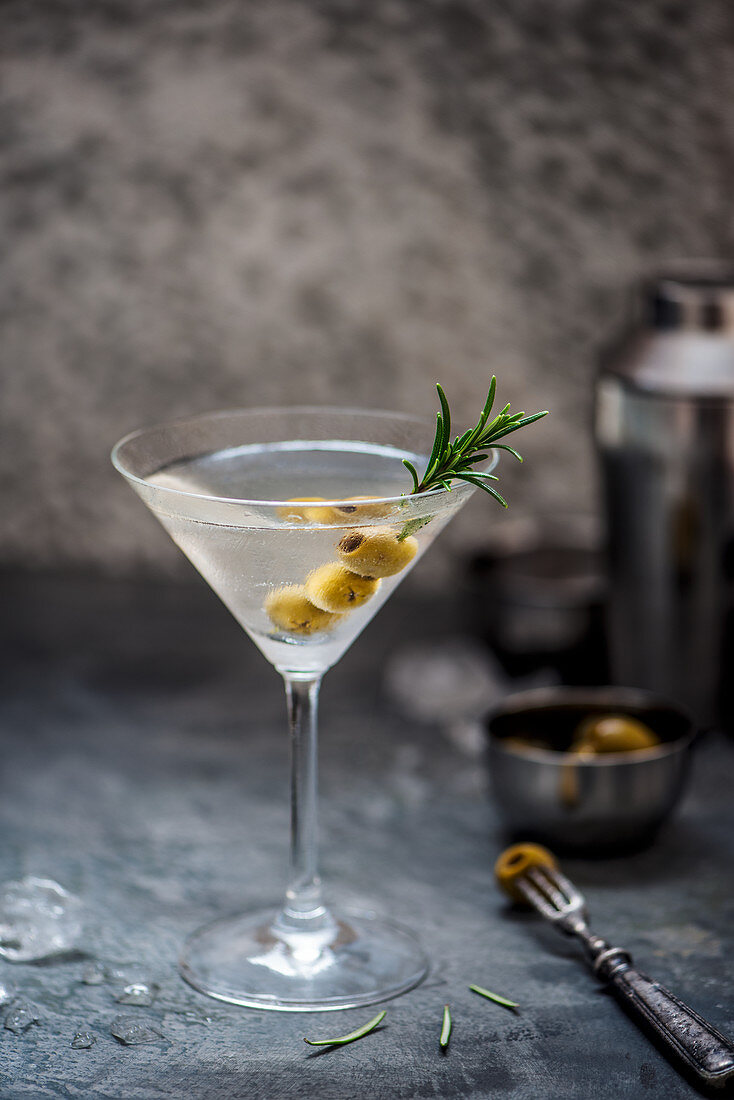 Martini cocktail with rosemary and olives