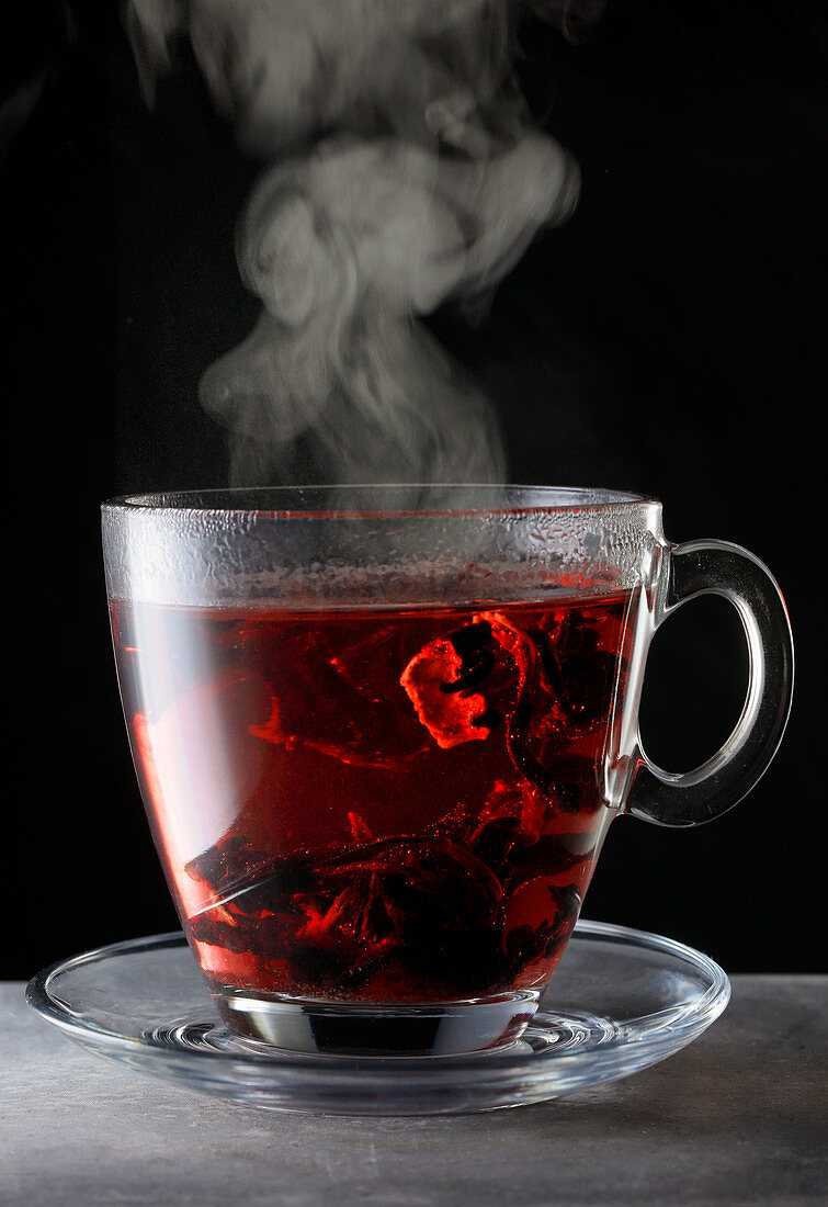 Steaming hibiscus tea in a glass cup