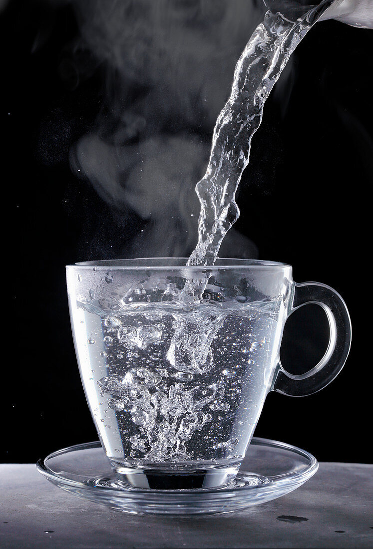 Kochendes Wasser in Glastasse eingiessen