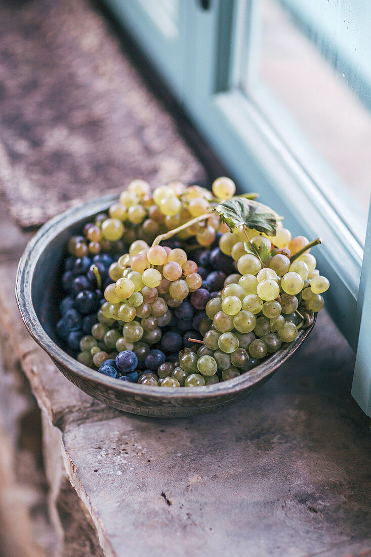 Grapes in a bowl on a window ledge
