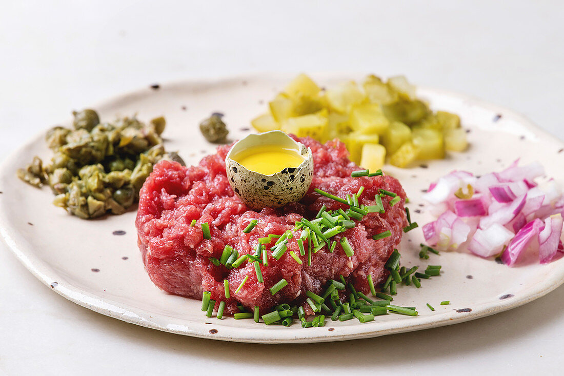 Rindertartar mit Wachtelei, Gurken, Kapern, roten Zwiebeln und Schnittlauch