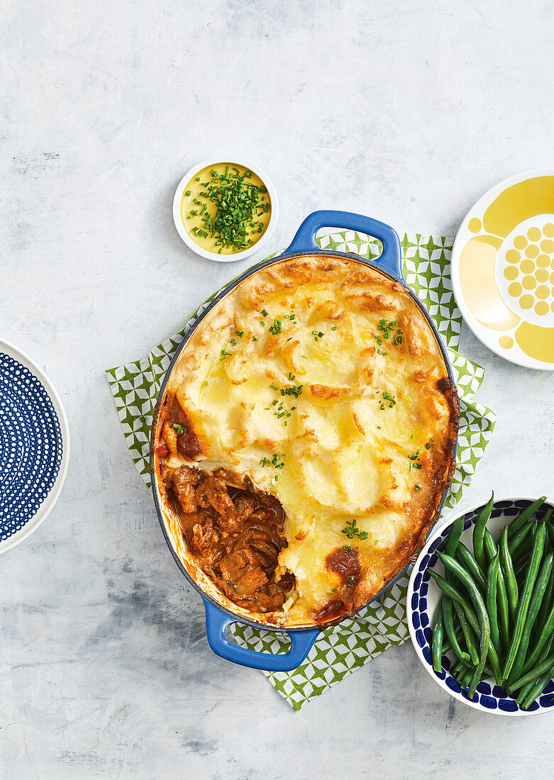 Stroganoff Cottage Pie serviert mit grünen Bohnen (England)