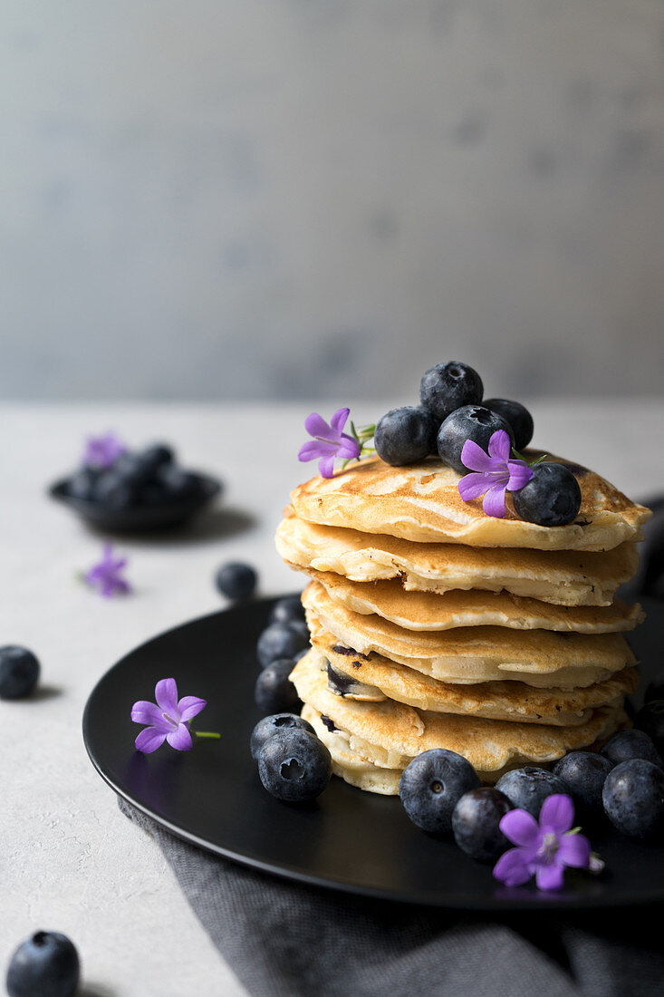 Stack of appetizing tasty crumpets with blueberries