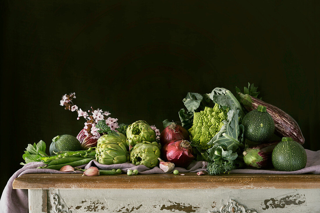 Stillleben mit grünem Gemüse auf rustikalem Holztisch