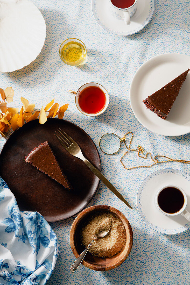 Schokoladen-Käsekuchen in Stücken auf Tellern serviert zum Tee (Aufsicht)