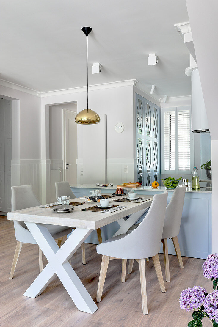 Upholstered chairs at dining table next to open-plan kitchen