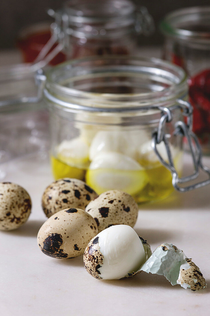 Ingredients for homemade pickled marinated quail eggs. Boiled eggs with olive oil in jar