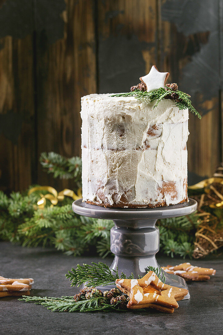 Christmas homemade white naked cake decorated by star cookie and green thuja branches