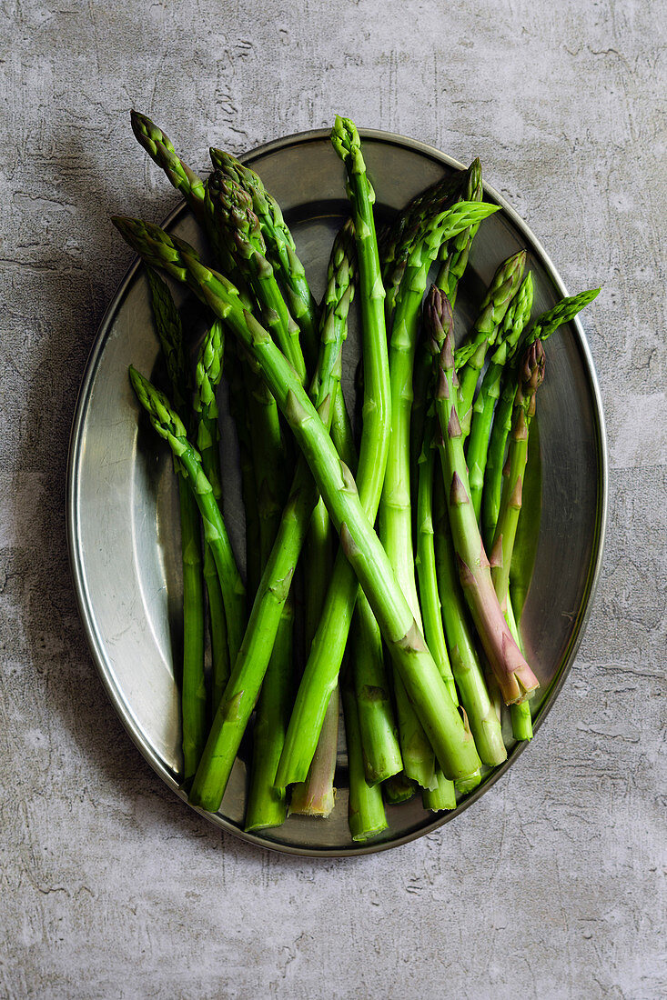 Raw asparagus spears on a plate