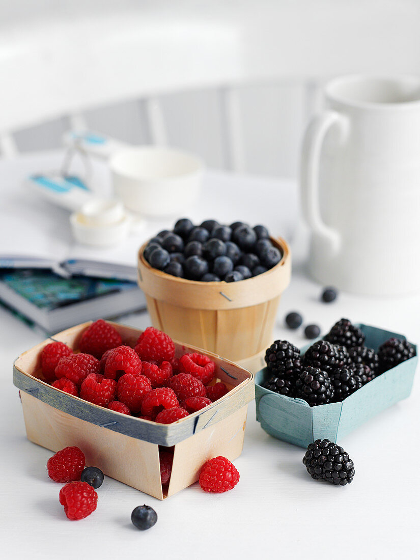 Raspberries, blueberries and blackberries in small bowls
