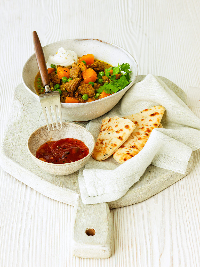 Indian lamb curry with cucumber raita butternut squash naan bread and chutney