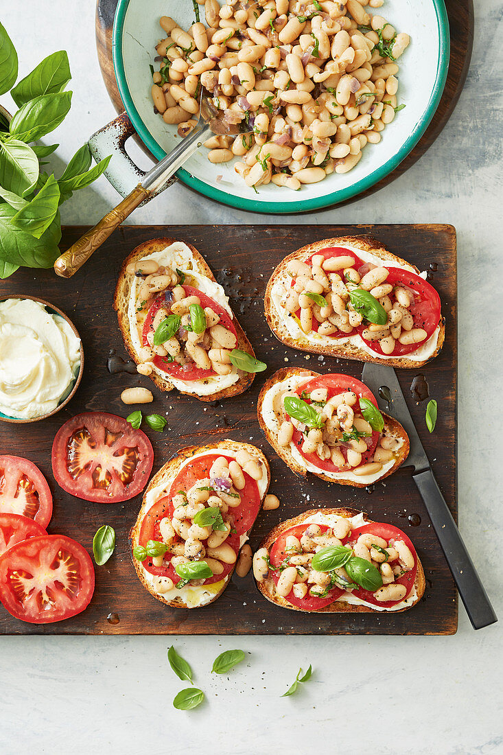 Röstbrotscheiben mit Ricotta, Tomaten und Fenchel-Bohnengemüse