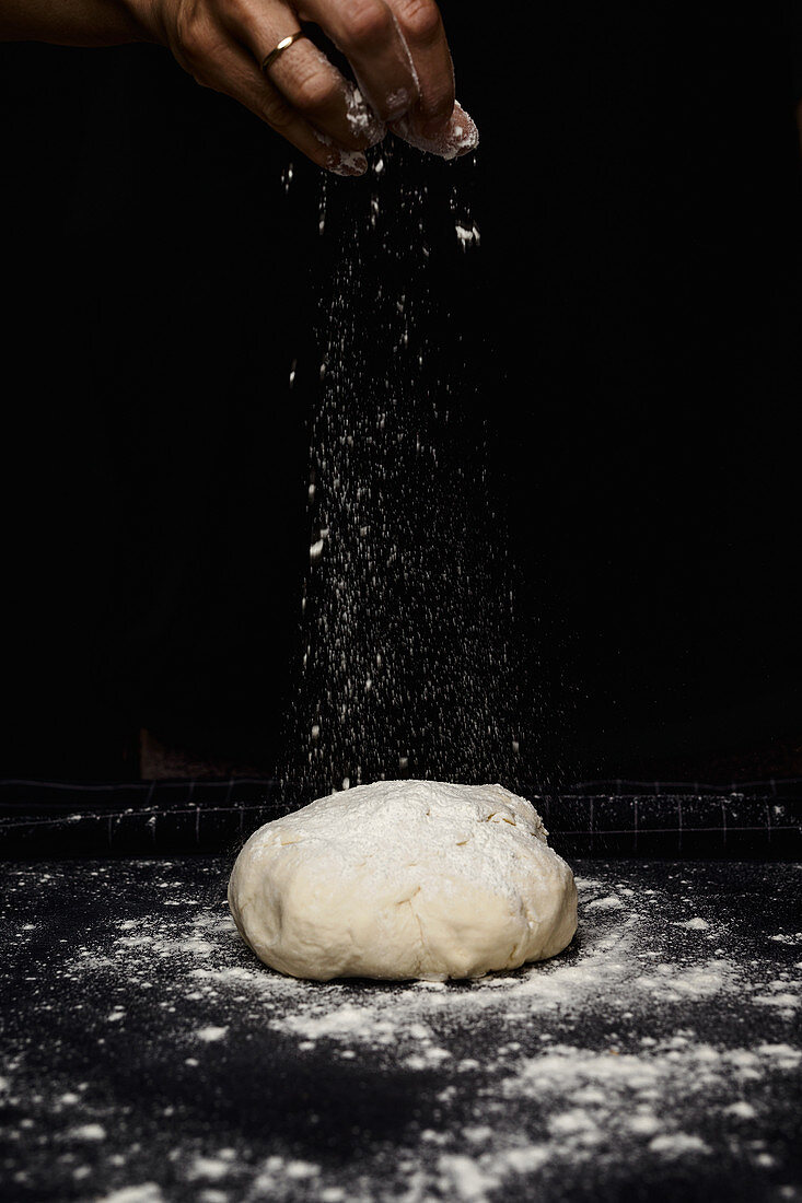 Woman's hands kneading bread on kitchen table