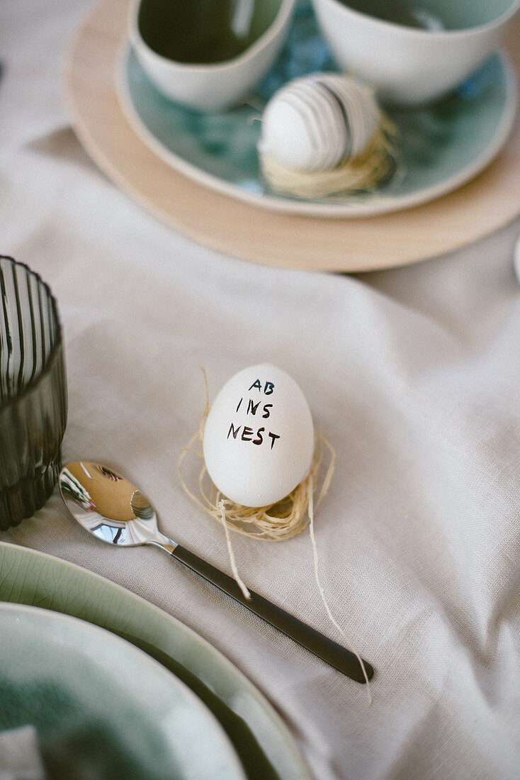 Easter egg decorated with lettering on set table