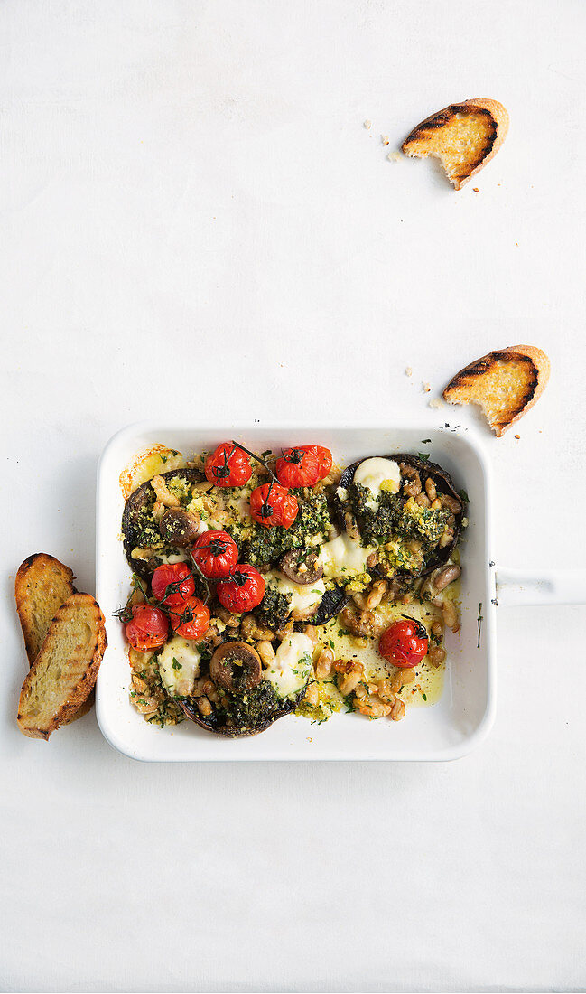 Mushroom casserole with pesto, cherry tomatoes and cheese