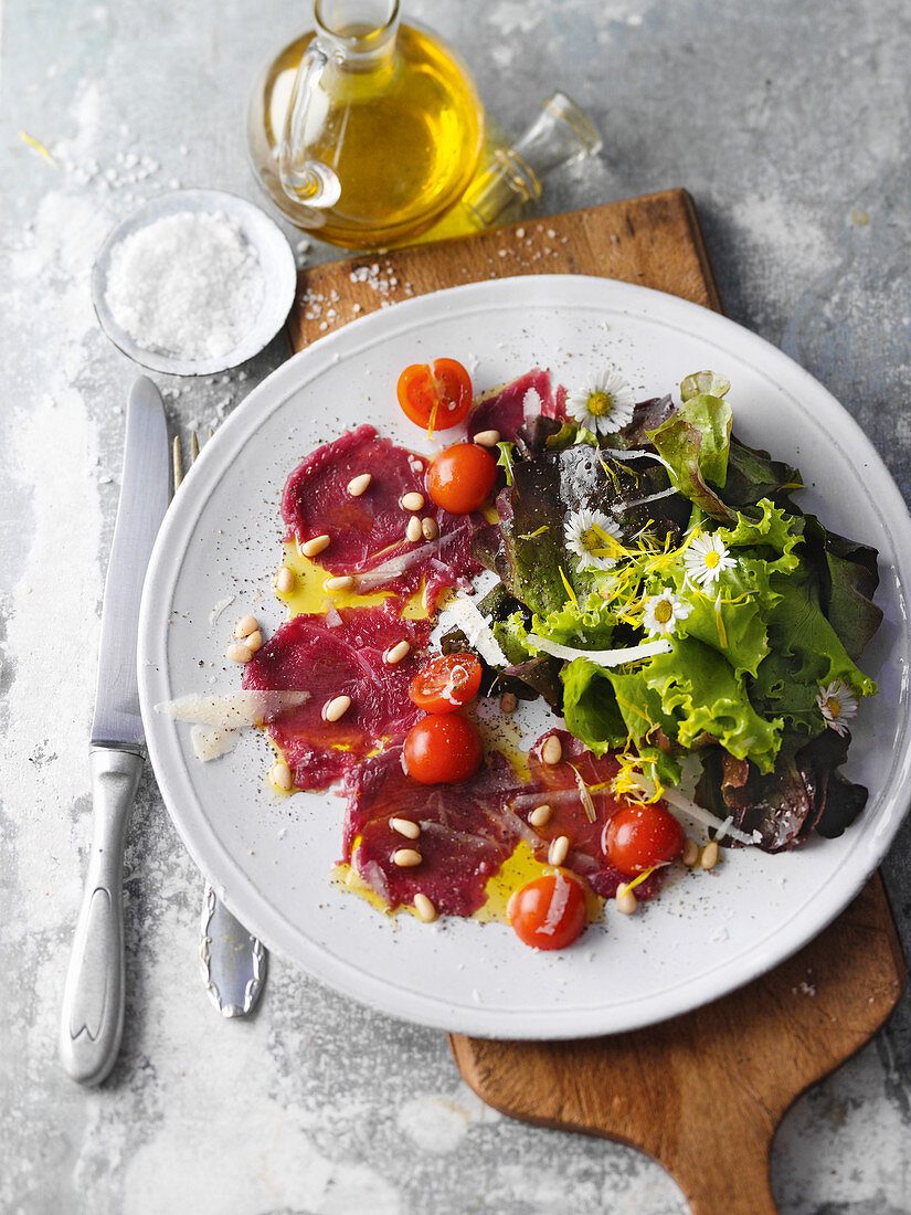 Saddle of venison carpaccio with a floral mixed leaf salad