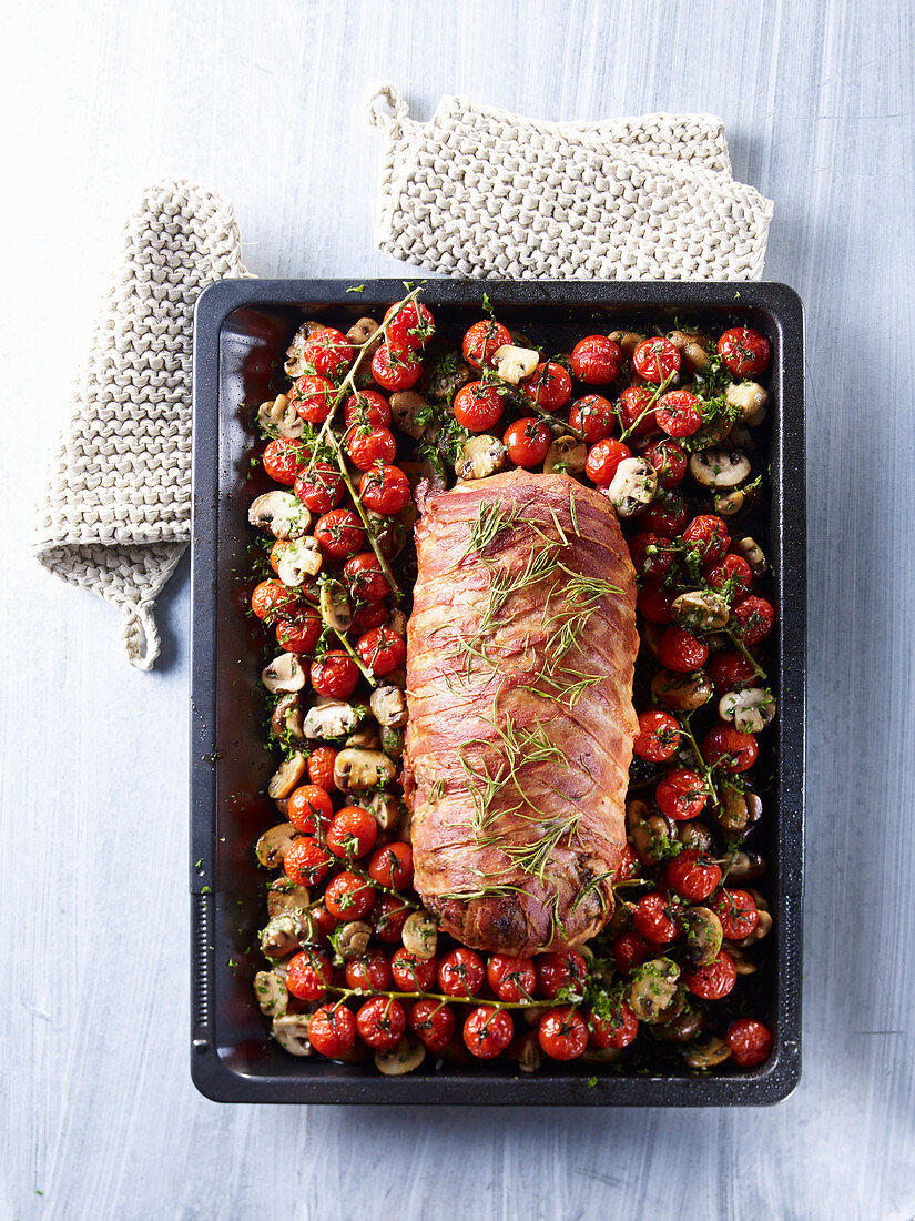 Meatloaf wrapped in bacon on cherry tomatoes