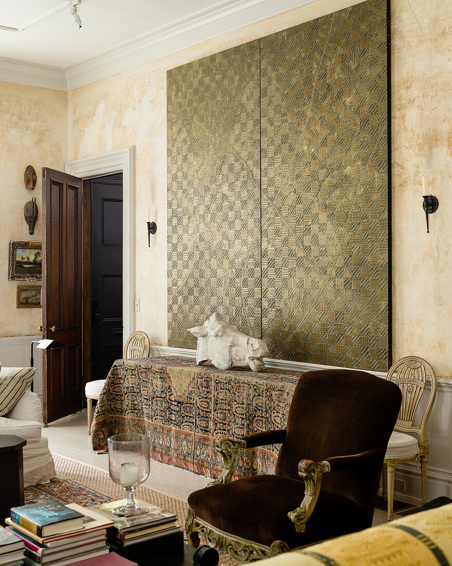 Large double panel painting with cross hatch pattern above table draped with oriental carpet