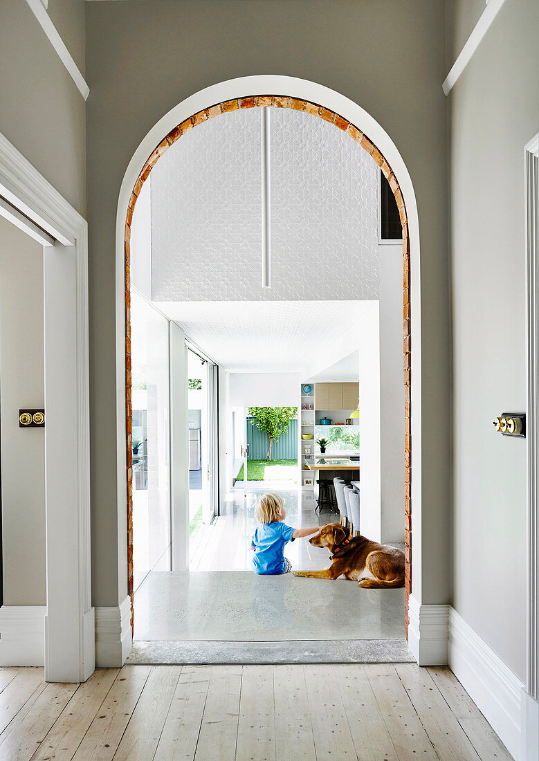 Hallway with arch, toddler with dog