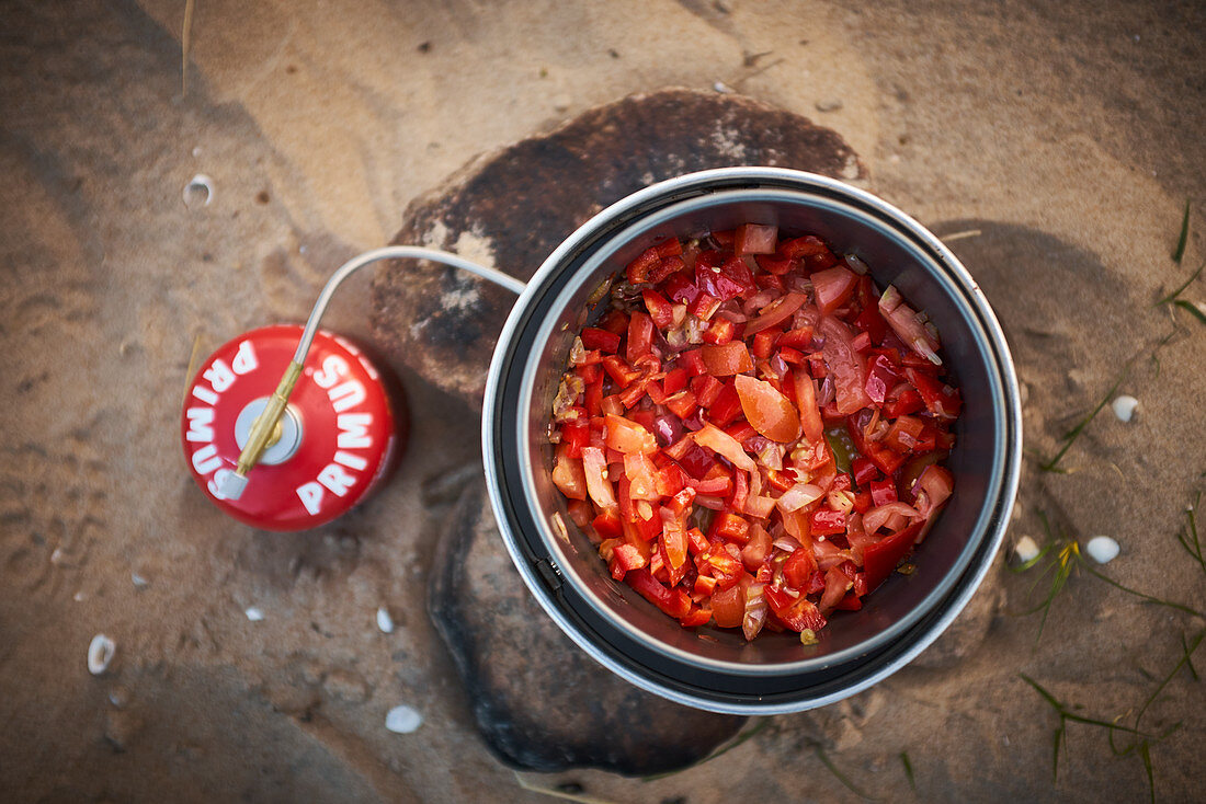Tomato sauce in a pot being cooked on a gas burner