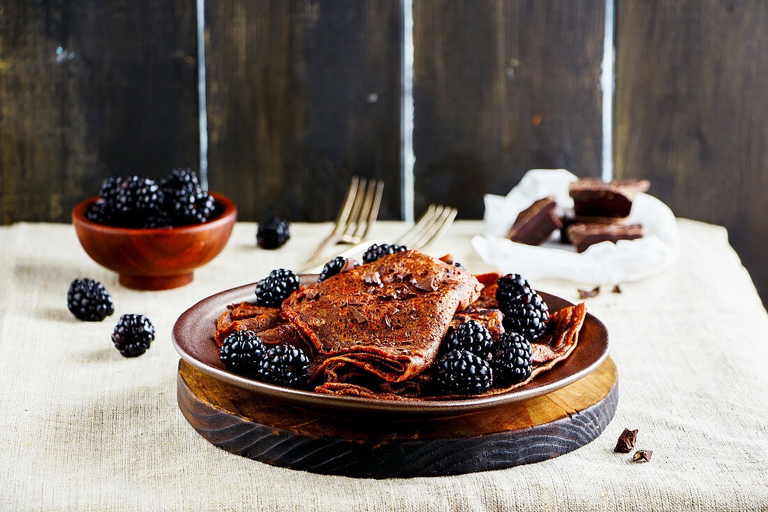 Thin chocolate pancakes with fresh blackberries