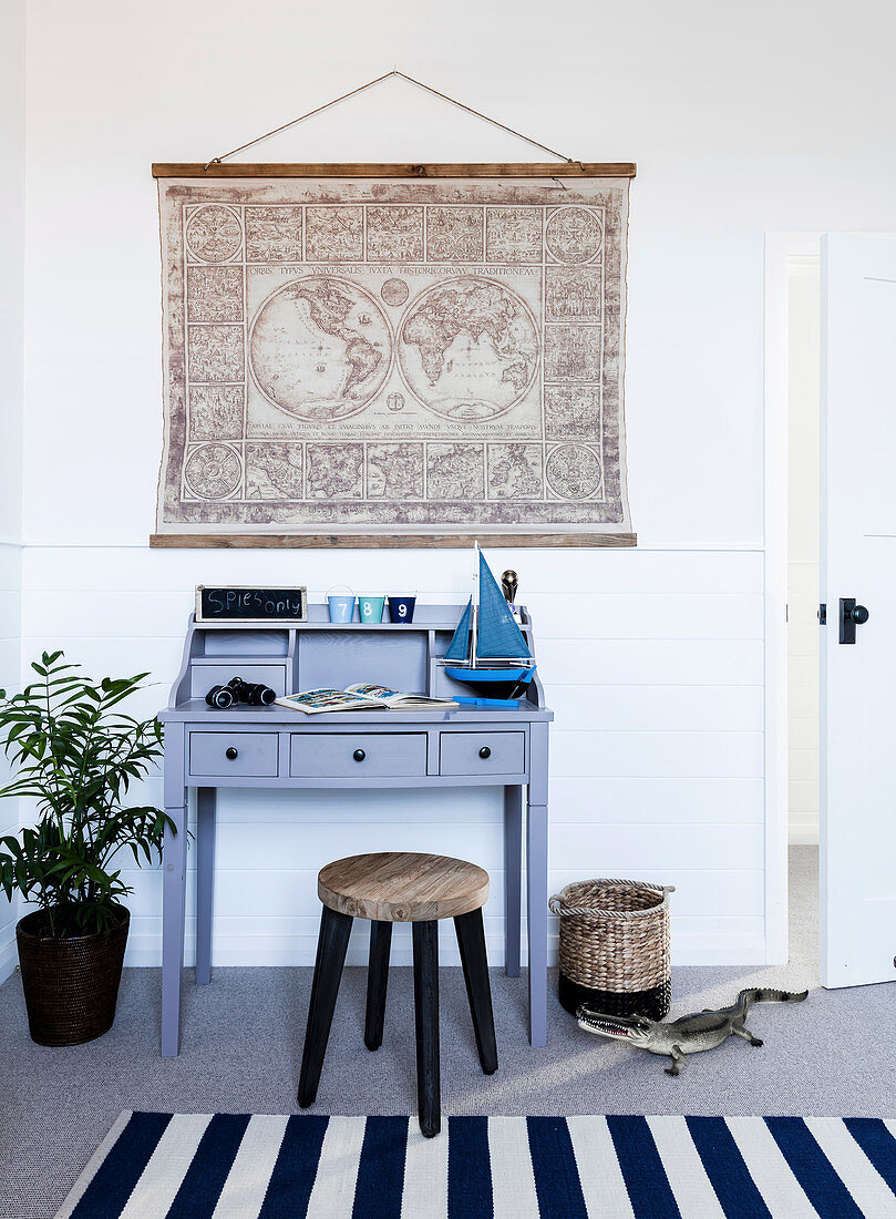 Secretary with model boat and stool, vintage map of the world above