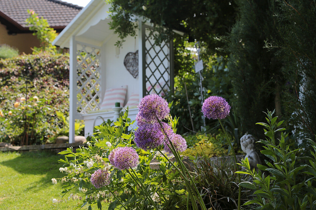 Sitzplatz in kleiner Gartenlaube, Zierlauch