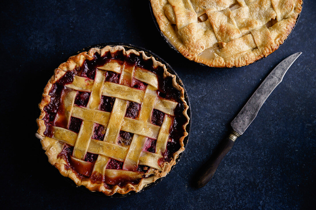 Apple pie and pie with berries on dark background
