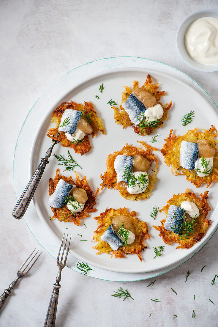 Potato latkes with pickled herring, apple sauce, sour cream and dill