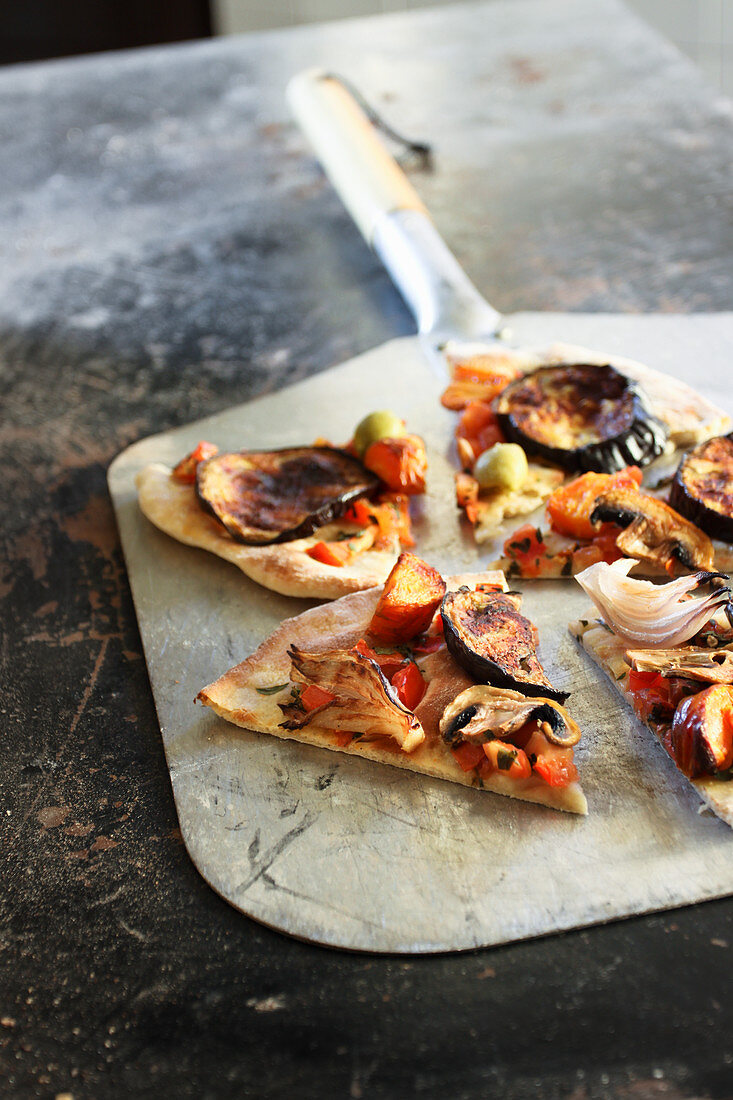 Eggplant pizza with mushrooms, olives, red pepper, red onion and roasted carrot topping