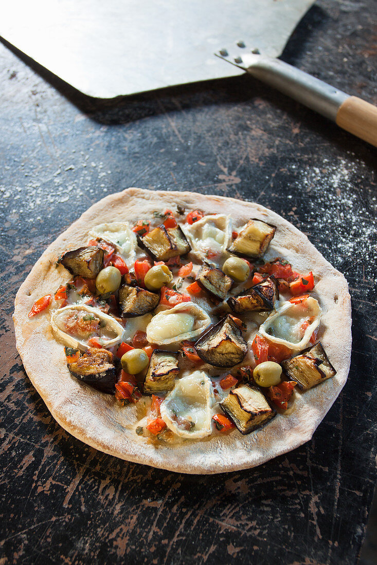 Stoned eggplant pizza with mushrooms, olives, red pepper, red onion and goat's cheese
