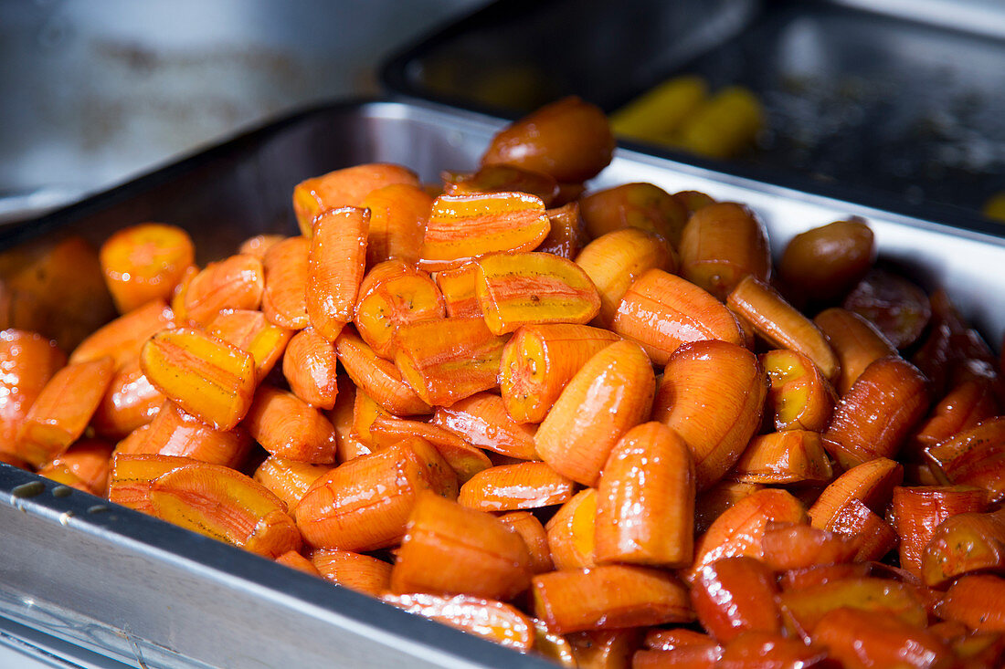 Shiny red pieces of banana in a street food stand in Klong Toei Market, Bangkok