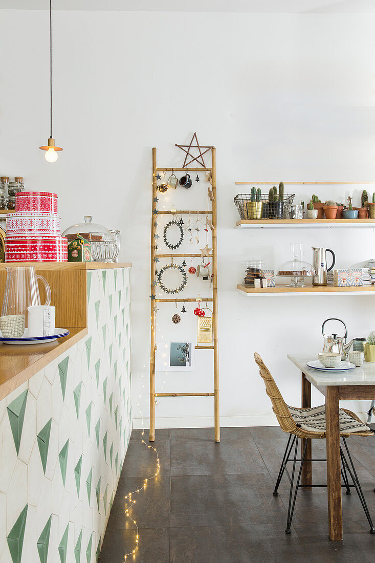 Festively decorated ladder in dining room next to open-plan kitchen