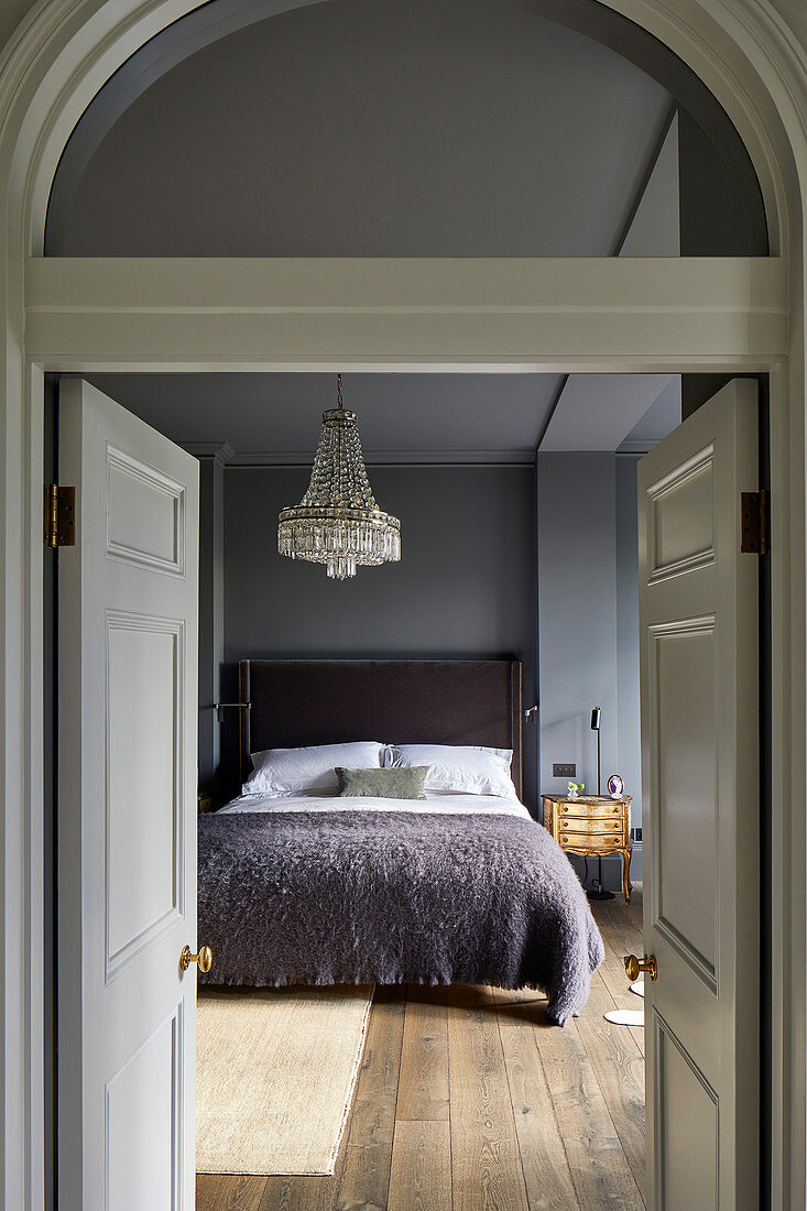 View into bedroom in shades of grey through open double doors