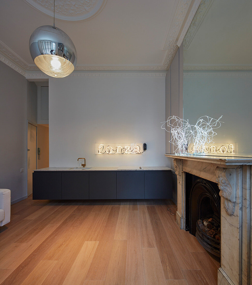 Modern kitchen counter and antique fireplace in minimalist kitchen