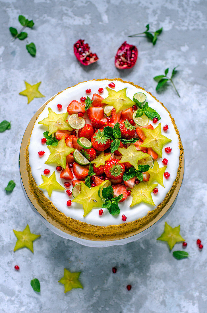 Cake decorated with strawberries, limequat, star fruit and mint