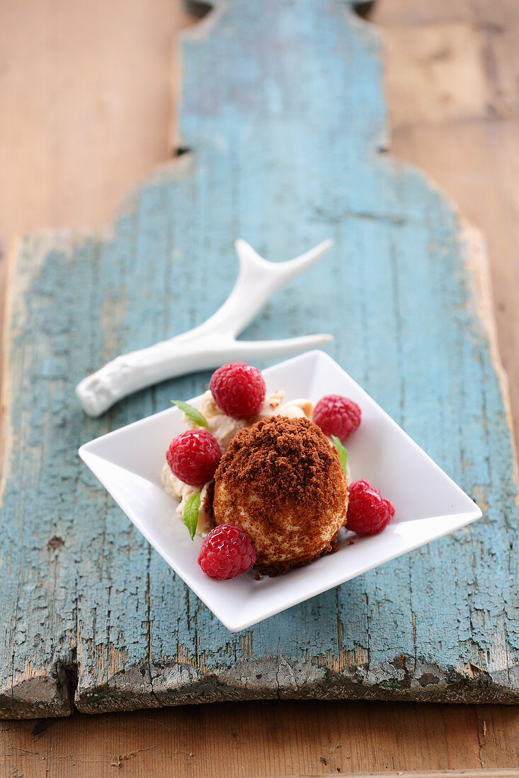 Quark dumplings with a nougat filling and rum and raisin ice cream with raspberries